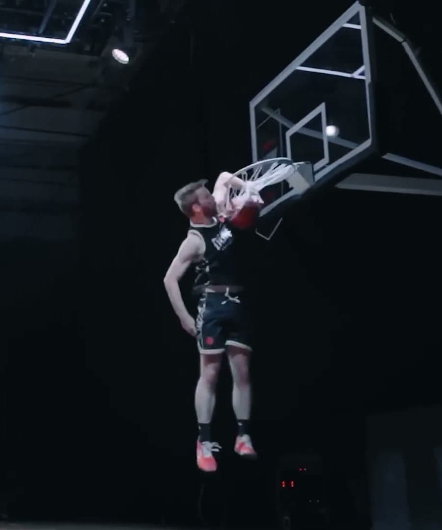 Connor Barth mid-dunk at a dunk contest, his hand on the rim